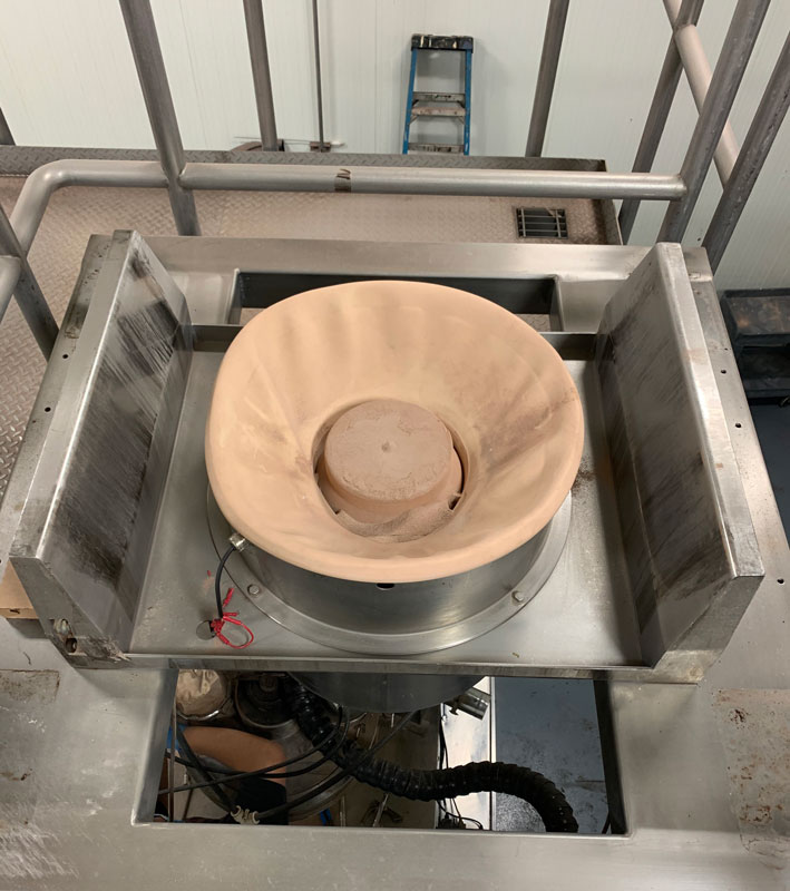 IBC discharge station raises and lowers cone valve inside IBC to dispense seasonings