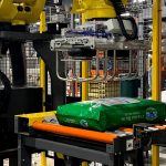 fanuc arm and tool picks bags of dog food and palletizes them in automatic system
