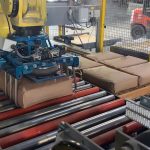 Fanuc robot picking up 100 lb. bag of minerals using a bag gripper tool