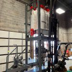 lifting a bulk bag super sack into the unloading station that feeds open mouth bagging machine
