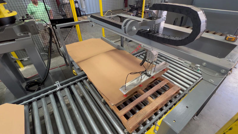 Automatic slip sheet dispenser placing sheet on pallet