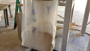 bagging coarse solar salt into plastic open mouth bags