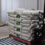 006-forklift-picking-up-pallet-of-bags-from-powered-roller-conveyor