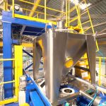 full IBC is convyed over discharge station to vibrating lifting deck