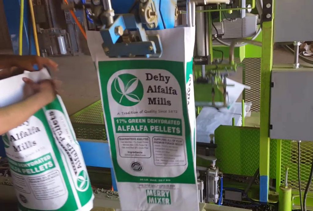 robotic bag placer hanging bag on spout of bag filler