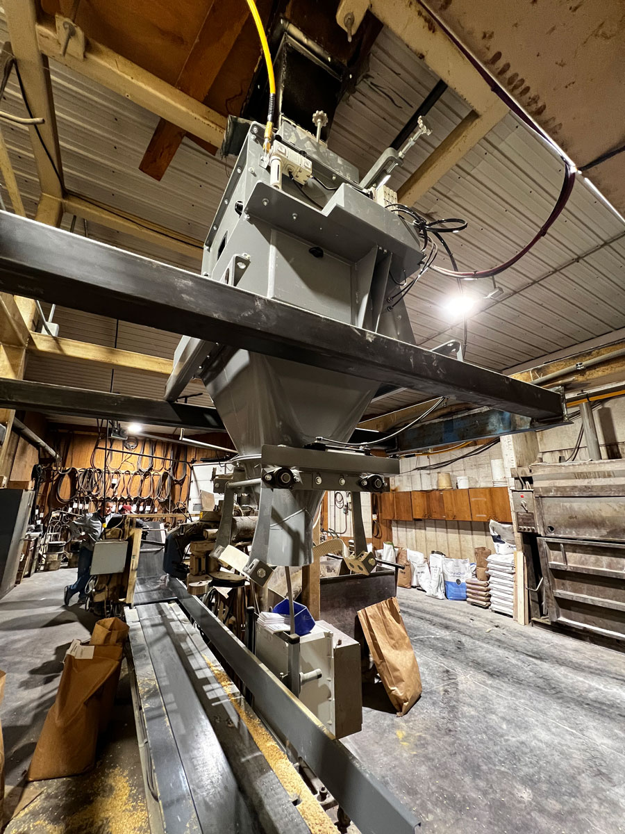 feed grain co op bagging machine with closing and palletizing conveyors