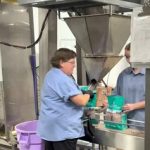 operator at small bag filling machine for pet food